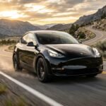 Tesla Model Y Performance driving on a scenic American highway during golden hour.